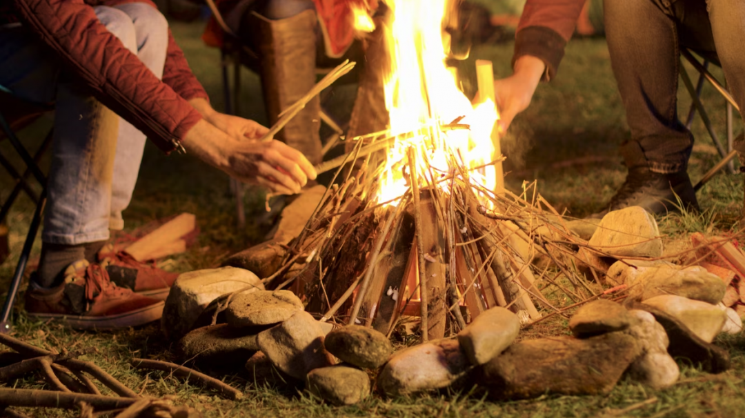 man making campfire for his friends on a cold night.