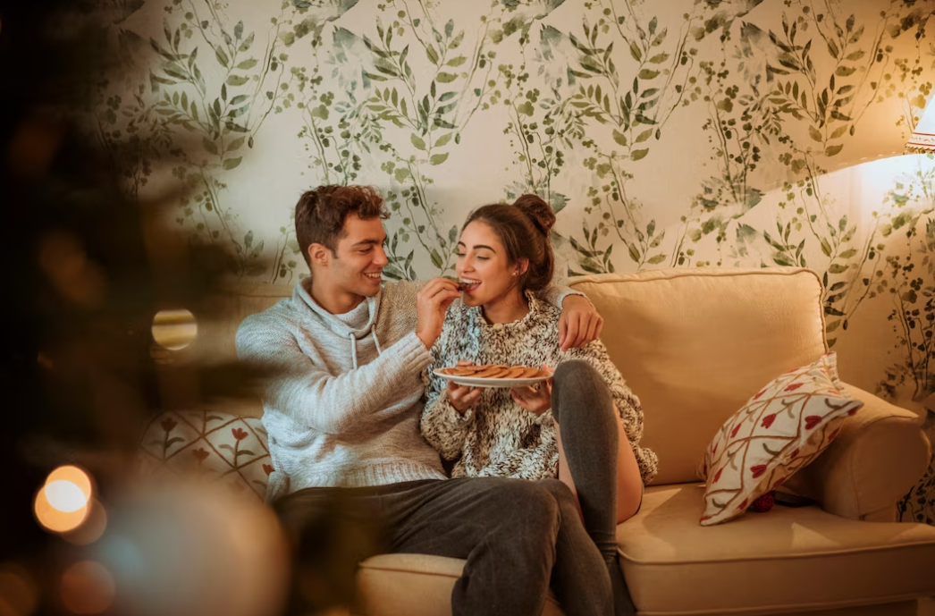 Man feeding woman with cookies