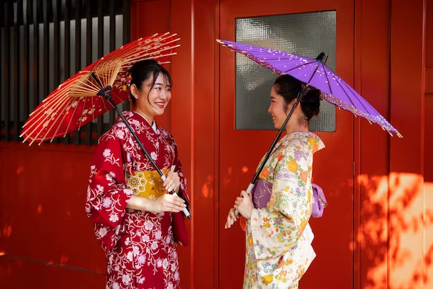 Image of two females wearing traditional Japanese kimonos and holding Japanese umbrellas.