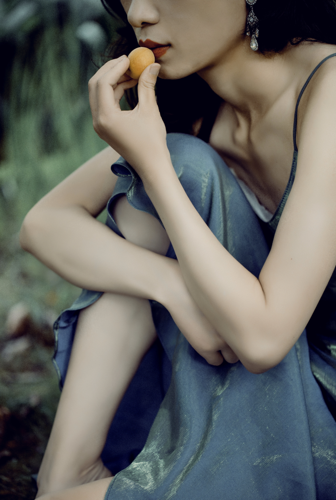 Girl is sniffing an apricot.