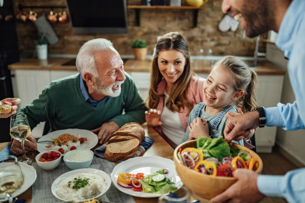 a happy family having fun while talking during lunch in the dining room focus is on the little girl