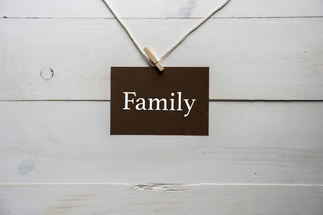 Closeup photo of a picture attached to a string with family written on it