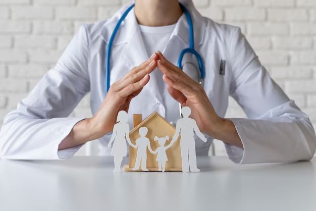 A doctor sits at a table next to a family figurine