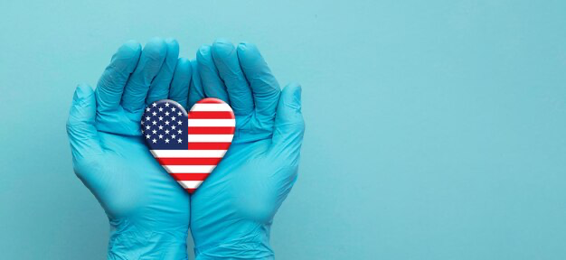 Hands in gloves hold an American flag icon in the form of a heart