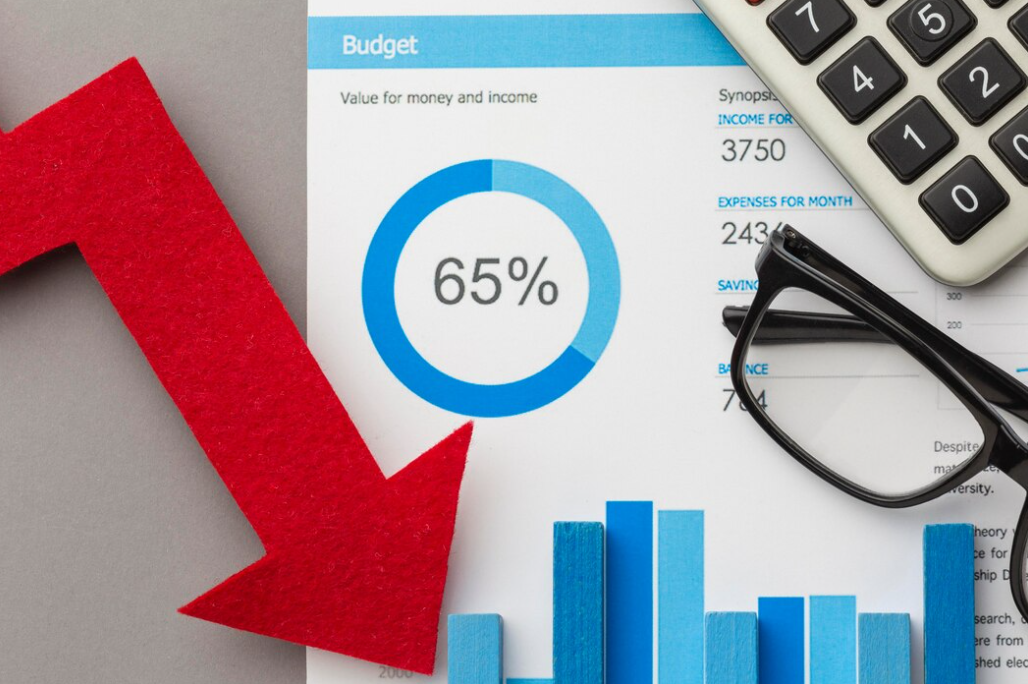 a red arrow, glasses, calculator, and sheet with a budget and blue graphs on i