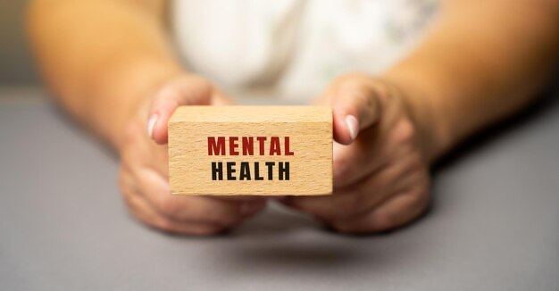 The inscription mental health on wooden blocks in female hands